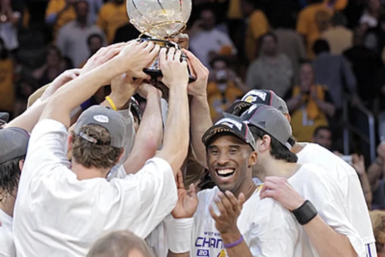 Lakers guard Kobe Bryant, right, celebrates with teammates as they raise the Western Conference Championship trophy after winning Game 5 of the NBA Western Conference finals against the Spurs on Thursday. (AP Photo/Mark J. Terrill)