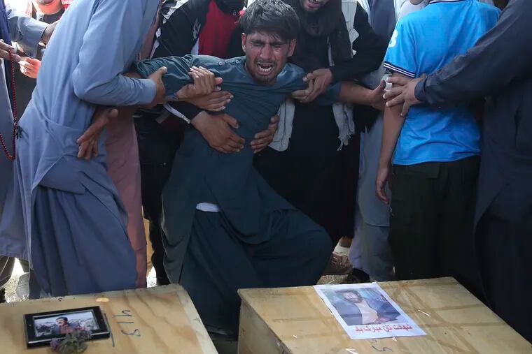 A relative wails near the coffins of victims of the Dubai City wedding hall bombing during a mass funeral in Kabul, Afghanistan, Sunday, Aug.18, 2019. The deadly bombing at the wedding in Afghanistan's capital late Saturday that killed dozens of people was a stark reminder that the war-weary country faces daily threats not only from the long-established Taliban but also from a brutal local affiliate of the Islamic State group, which claimed responsibility for the attack.