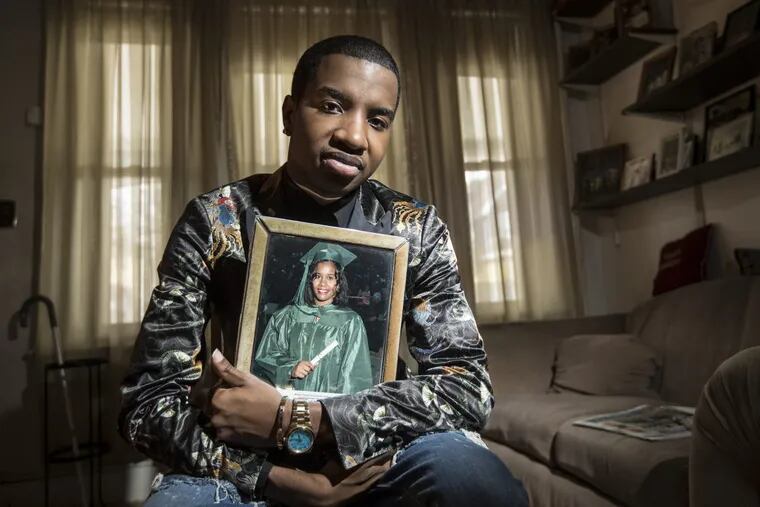 Karel Rue holds onto a portrait of his mother, Laciana Tinsley, who is being held in the murder of her second husband.