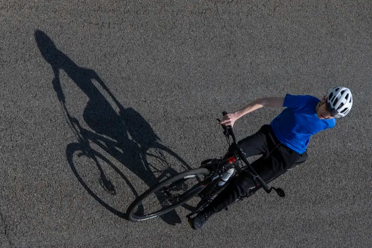 Mid day sun cast shadow of recreational cyclist as seen from Spring Garden bridge on Thursday.