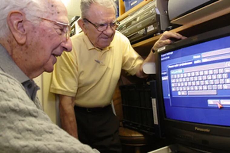 In the control room of Channel 11, volunteers Len Orlando (left) and Jim Pericles check a video monitor.
