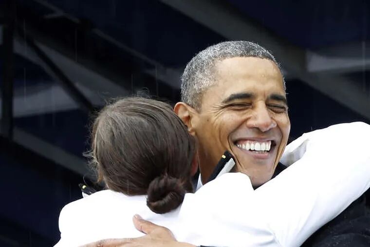 President Obama congratulates Alexis Marisa Werner with open arms during the U.S. Naval Academy commencement ceremony in Annapolis, Md.