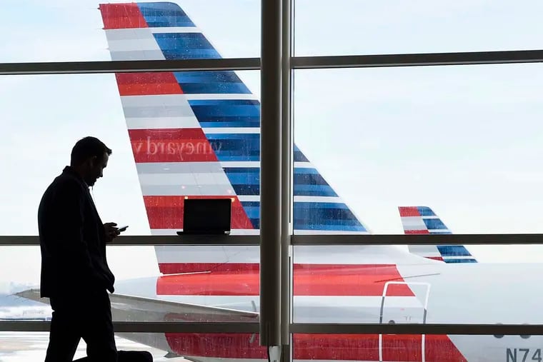 FILE: A passenger talks on the phone as American Airlines jets sit parked at their gates at Washington's Ronald Reagan National Airport.