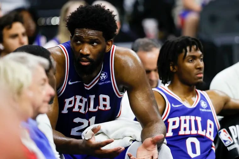 Sixers center Joel Embiid and guard Tyrese Maxey (0) sit on the bench late in Game 5.