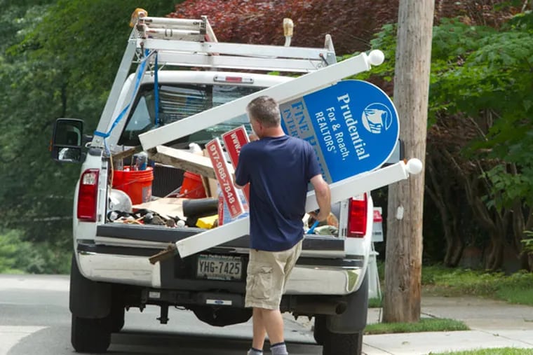 An unidentified maintenance worker removes the for sale sign from 117 Booth Road, Haverford, late Thursday morning. ( Ed Hille / Staff Photographer )