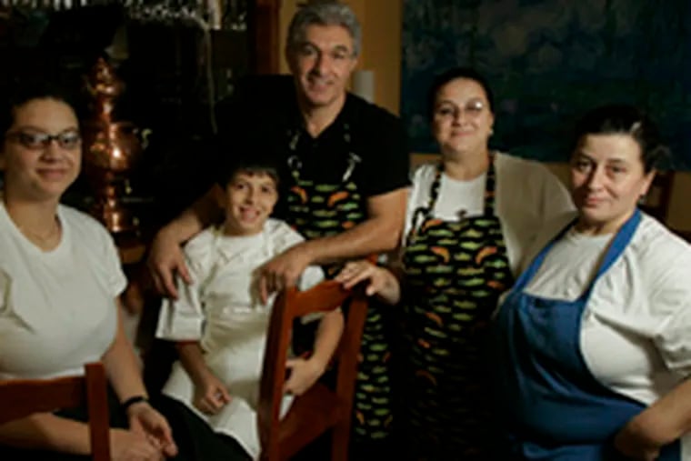 Riza Canca (center) with (from left) daughter Doga, son Sadik, wife Gul, and mother-in-law Kiymet Kucukoglu at their Turkish restaurant Fish & Grill, in a modest strip center in the Northeast.