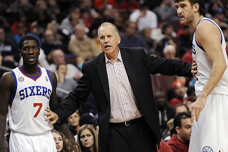 Philadelphia 76ers coach Doug Collins, center, hold back Spencer Hawes
(00) and Royal Ivey as he talks to an official during the second half
of an NBA basketball game against the Cleveland Cavaliers, Sunday,
Nov. 18, 2012, in Philadelphia. The 76ers won 86-79. (AP Photo/Michael
Perez)