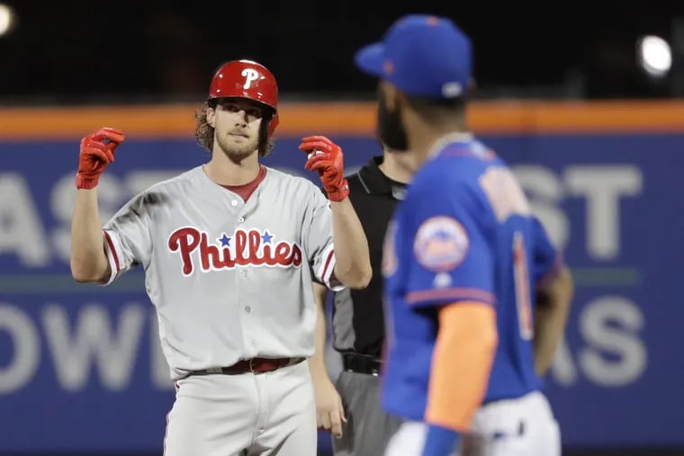 Aaron Nola gestures to teammates after hitting a three-run double during the fifth inning of the Phillies' 3-1 win against the Mets Monday. The Phillies split a doubleheader with New York by taking the nightcap.