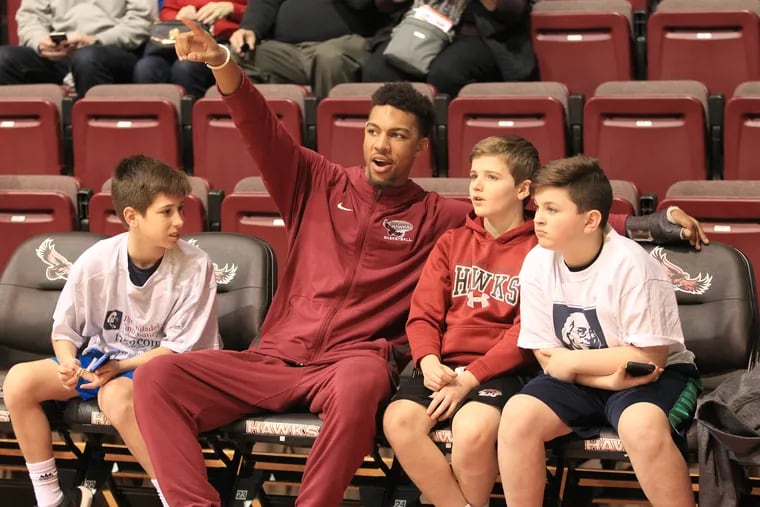 Injured Hawk star Charlie Brown of St. Joseph's sits with some young fans before their game against Massachusetts at Hagan Arena on Feb. 10, 2018. Charlie has missed all season with a broken hand. CHARLES FOX / Staff Photographer
