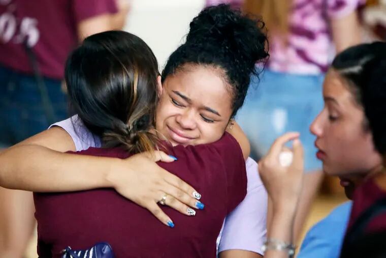 Fellow students from Little Flower High School comfort each other following a prayer service for 17-year-old Jaylin Landaverry on Wednesday July 23, 2014, at Little Flower High School in the Hunting Park section of Philadelphia. Landaverry died Tuesday night at Temple University Hospital from the injuries she suffered during a July 1, 2014, food truck explosion.