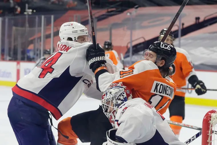 Flyers right winger Travis Konecny gets shoved into Washington Capitals goaltender Ilya Samsonov by defenseman John Carlson during the first period Sunday.  Konecny was called for an interference penalty on the play.