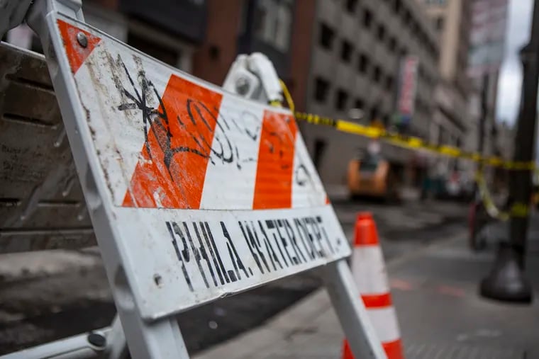 Barriers closed off 13th and Sansom Streets in Center City following a massive water main break in 2019. The cost of such repairs is one of the reasons cited by the Philadelphia Water Department in its request for a nearly 17% rate increase phased in over the next two years.