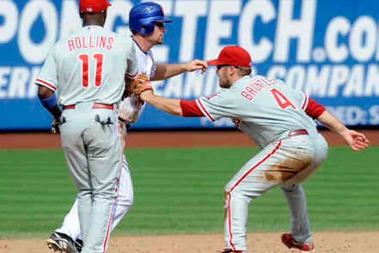 Phillies second baseman Eric Bruntlett completes his unassisted triple play, tagging the Mets' Daniel Murphy.