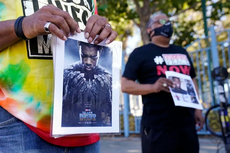 A portrait of the late actor Chadwick Boseman as the character T'Challa in the 2018 film "Black Panther" is held by a participant in a news conference celebrating his life, Saturday, Aug. 29. 2020, in Los Angeles. Boseman died Friday at 43 after a four-year fight with colon cancer.
