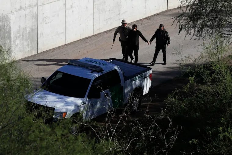 FILE - In this Nov. 16, 2016, file photo, a U.S. Customs and Border Patrol agent walks with suspected immigrants caught entering the country illegally along the Rio Grande in Hidalgo, Texas. While the Trump administration focuses attention on migrant caravans trying to cross the southern U.S. border in California, migration is surging at the opposite end of the border in South Texas. (AP Photo/Eric Gay, File)