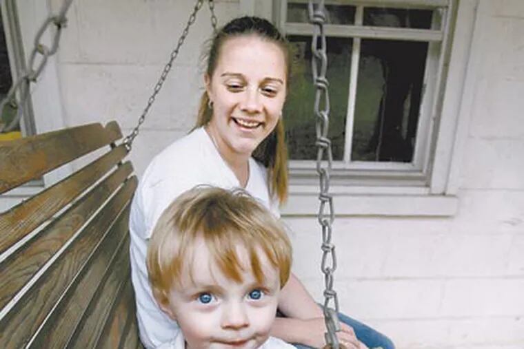 Calvin and his mother, Erin Curtis, share a swing on the porch of her grandmother’s house in Schwenksville, which Curtis hopes to convert to a haven for bereft families — like hers. (CHARLES FOX / Staff Photographer)