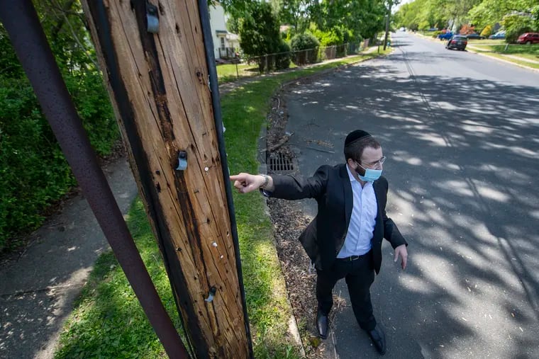 Mordechai Burnstein, a Jackson resident and a leader in its Orthodox Jewish community, points out a strip of 1-inch black pipe, denoting an eruv attached to a utility pole in Jackson, N.J. on Friday, May 14, 2021.