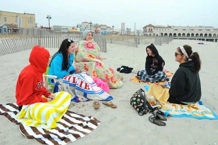 And why not? In Ocean City on Thursday, college students enjoy a chilly day at the beach. A warmer winter has been good for business. (Clem Murray / Staff Photographer)