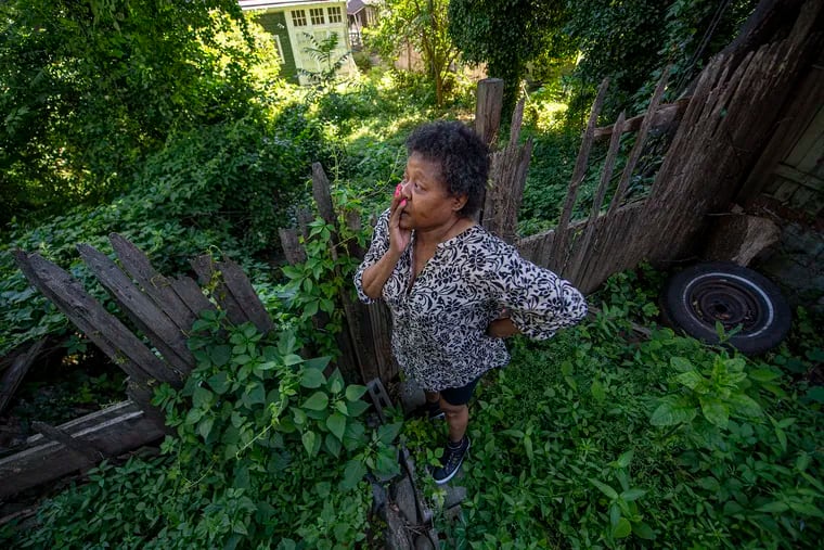 Linda Smalley at her home in Philadelphia. In 2016, a tree from a vacant lot near her house fell into her yard, damaging her fence and deck. Since then, she's been trying to get help to remove it.
