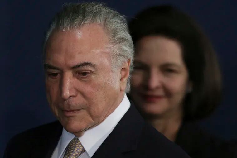 FILE - In this Sept. 18, 2017 file photo, Brazil's President Michel Temer arrives for the swearing-in ceremony for newly named Attorney General Raquel Dodge, pictured in background, in Brasilia, Brazil. Dodge says that Temer is at the epicenter of ongoing institutionalized corruption and sent a request directly to the Supreme Court late Wednesday, Dec. 19, 2018, to charge him with corruption and money laundering. (AP Photo/Eraldo Peres, File)