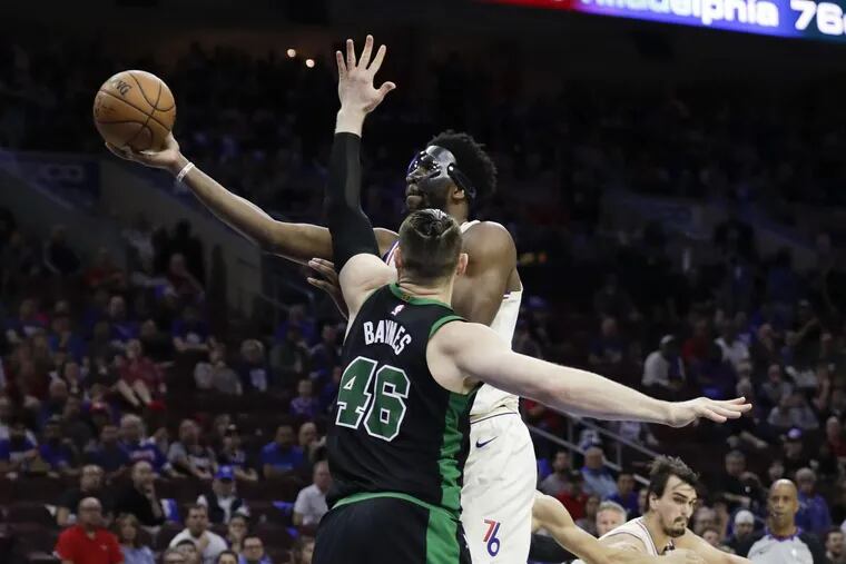 Joel Embiid lays-up the basketball against Celtics center Aron Baynes during Game 3.