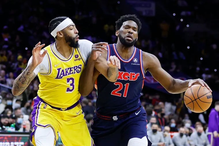 Sixers center Joel Embiid dribbles the basketball against Los Angeles Lakers forward Anthony Davis during the first quarter on Thursday.