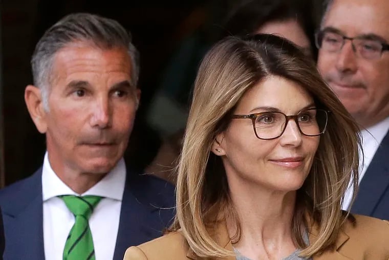 Actress Lori Loughlin (front) and her husband, clothing designer Mossimo Giannulli, depart federal court in Boston earlier this month.