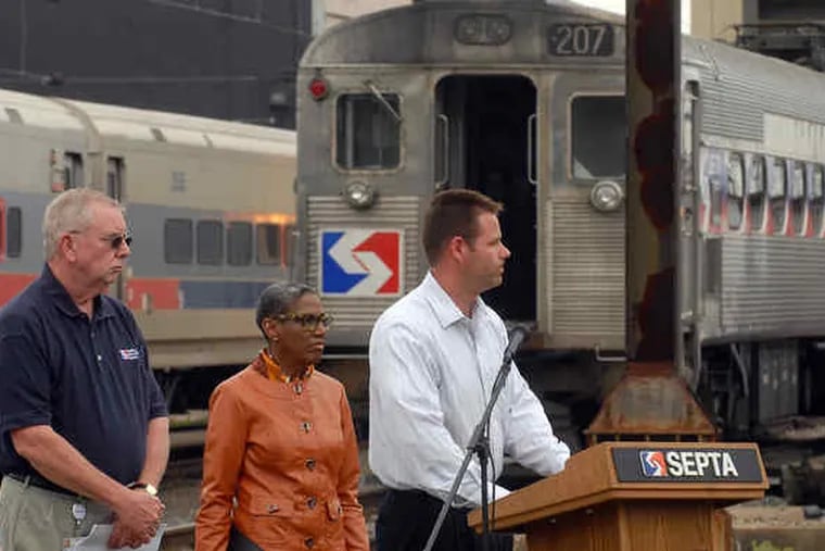 Jim Fox, director of system security for SEPTA, speaks at a news conference at the agency's Wayne facility. With him are James B. Jordan (left) and Frances Jones, assistant general managers for SEPTA. At right is a rooftop pantograph of the sort involved.