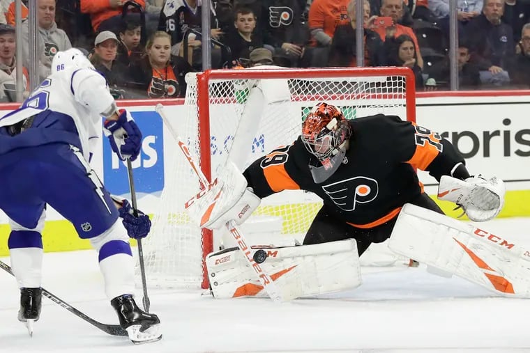 Flyers goaltender Carter Hart stops the puck against Lightning right wing Nikita Kucherov.