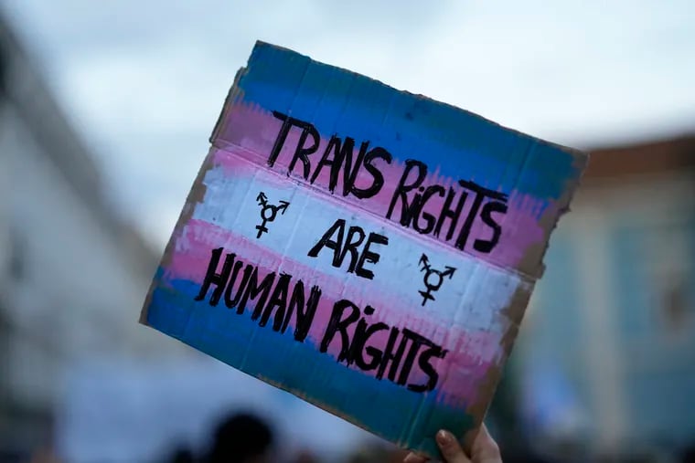 A demonstrator holds up a sign during a march to mark International Transgender Day of Visibility.