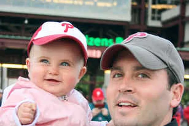 Gearing up for Game 1 of the Series, Brian McCollum and daughter Sarah Carmel, 1, of Delaware County, take in an Irish Night game at Citizens Bank Park.