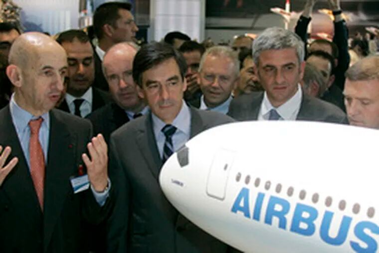 Airbus chief Louis Gallois (from left), French Prime Minister Francois Fillon and French Defense Minister Herve Morin look at a model of Airbus A350-XWB jet.