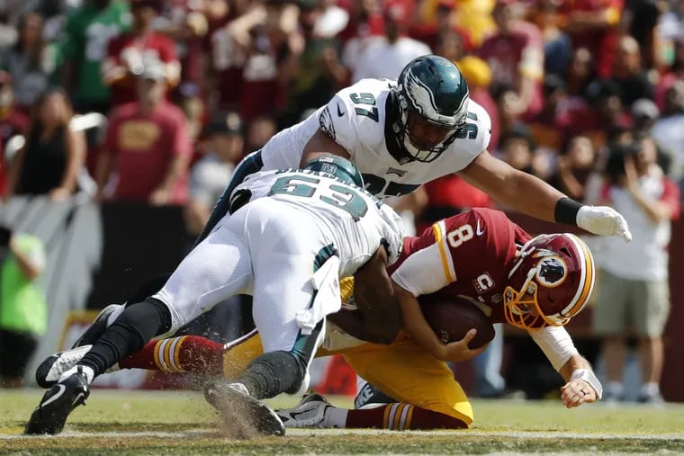 Washington Redskins quarterback Kirk Cousins, bottom right, slides as he is pressured by Philadelphia Eagles defensive tackle Destiny Vaeao, top, and outside linebacker Nigel Bradham in the second half of an NFL football game, Sunday, Sept. 10, 2017, in Landover, Md. (AP Photo/Alex Brandon)