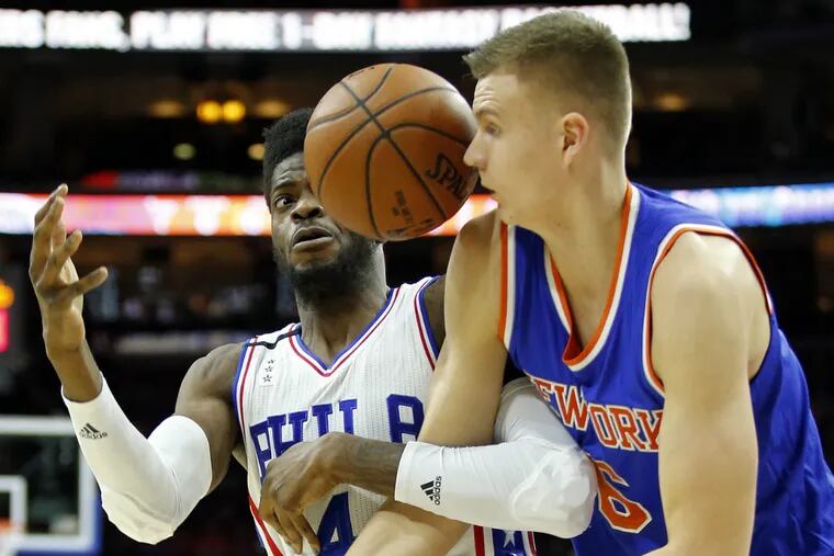 Sixers' Nerlens Noel and New York Knicks' Kristaps Porzingis battle for the loose basketball during the first quarter on Friday night. (Yong Kim / Staff Photographer)