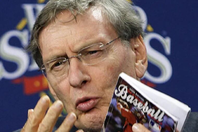 Baseball commissioner Bud Selig held up the rulebook when he announced Game 5 of the World Series was suspended in Philadelphia on Monday. (AP Photo / Gene J. Puskar)