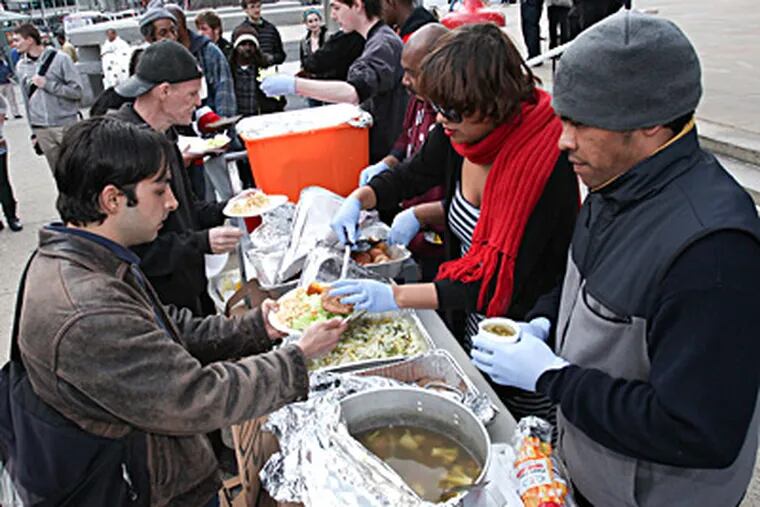 Occupy Philadelphia protesters dished out free food and soup Thursday outside the Municipal Services Building, where a Health Department meeting was being held on Mayor Nutter's controversial plan to eventually ban outdoor feeding programs in city parks. STEVEN M. FALK / Staff Photographer