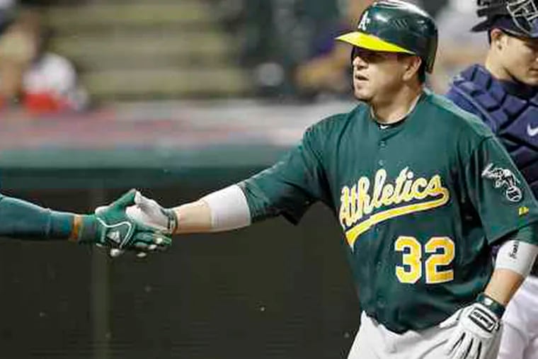 The A's Jack Cust (32) is greeted after his two-run home run Tuesday.