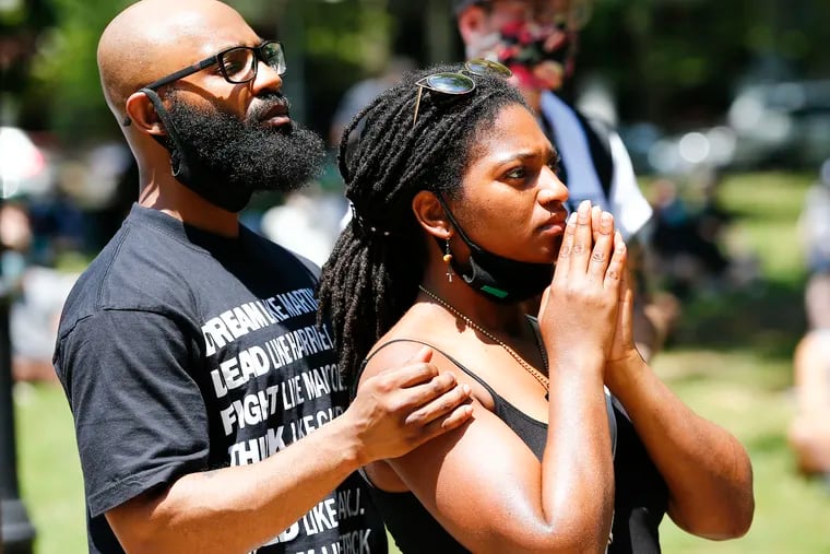 Irik Robinson (left) and  his wife, Taslim Patterson, listen to speakers during a Rally for Political Prisoners at Malcolm X Park in West Philadelphia on Sunday.