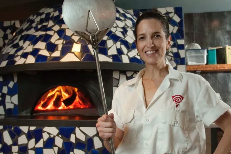 Stephanie Reitano, owner/chef of Capofitto, by her wood-fired pizza oven, which reaches 900 degrees and cooks a pizza in 90 seconds.