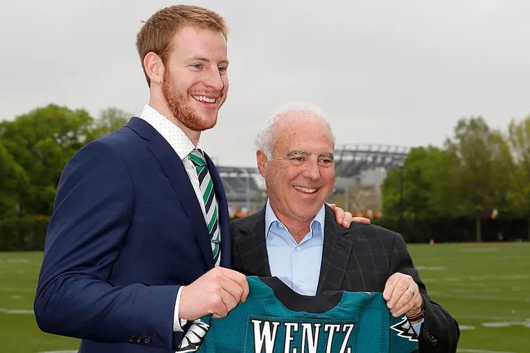 Eagles quarterback Carson Wentz, holds his jersey with Eagles owner and chairman Jeffrey Lurie.
