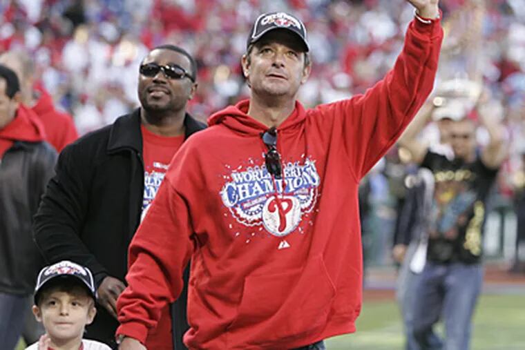 Jamie Moyer waves to the crowd as he walks around the stadium with his son. (Michael Bryant / Staff Photographer)