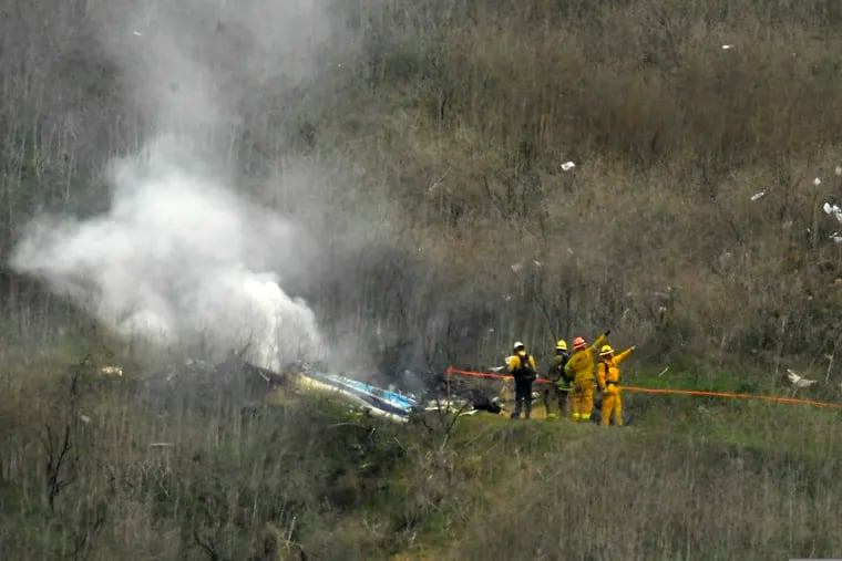 Firefighters work the scene of a helicopter crash where former NBA star Kobe Bryant died, in Calabasas, Calif on Jan. 26, 2020.