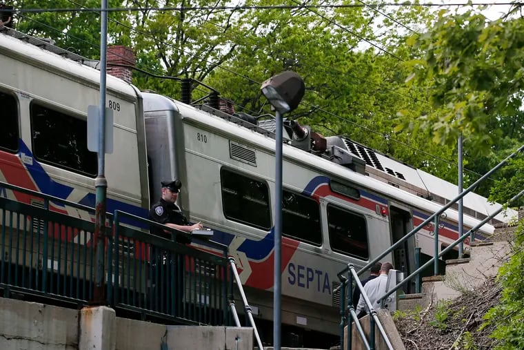 A SEPTA Transit Police officer stands near a Chestnut Hill West line train at the Carpenter Station in West Mount Airy after a train conductor was shot on the platform there Friday, May 10, 2019.