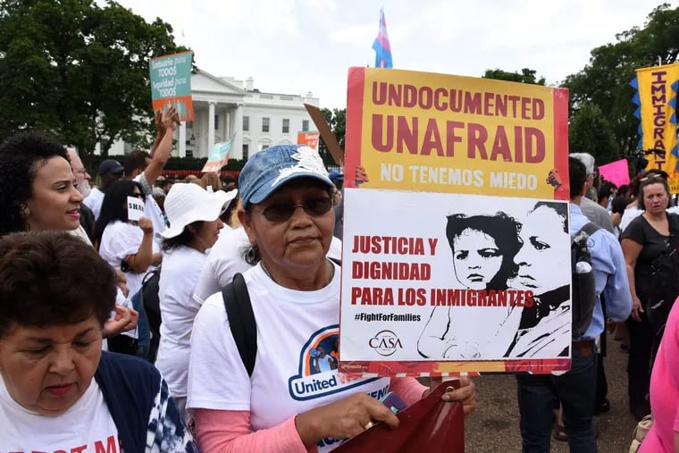 Protesters hold up signs during a rally supporting Deferred Action for Childhood Arrivals, or DACA, outside the White House on Tuesday, Sept. 5, 2017. Thousands are expected to gather for rallies on Tuesday, when President Donald Trump is slated to announce the program's future. (Olivier Douliery/Abaca Press/TNS)