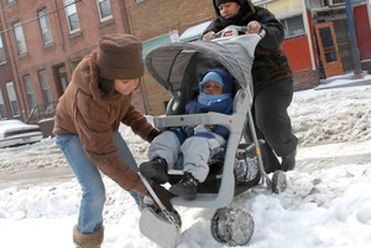Getting around Philadelphia was tough yesterday no matter what your wheels. Cierra Hines, 12, helps lift Collin Hines&#0039; stroller, with mother Denkei Lawson at 15th and Mifflin in South Phila.