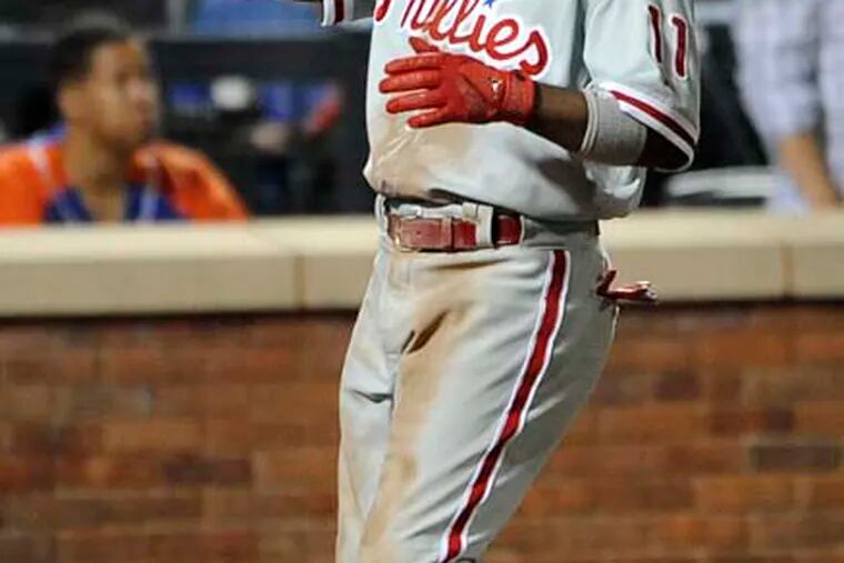 The Phillies' Jimmy Rollins points skyward on his way to home plate after hitting a three-run homer against the Mets in the ninth inning. (Kathy Kmonicek/AP)