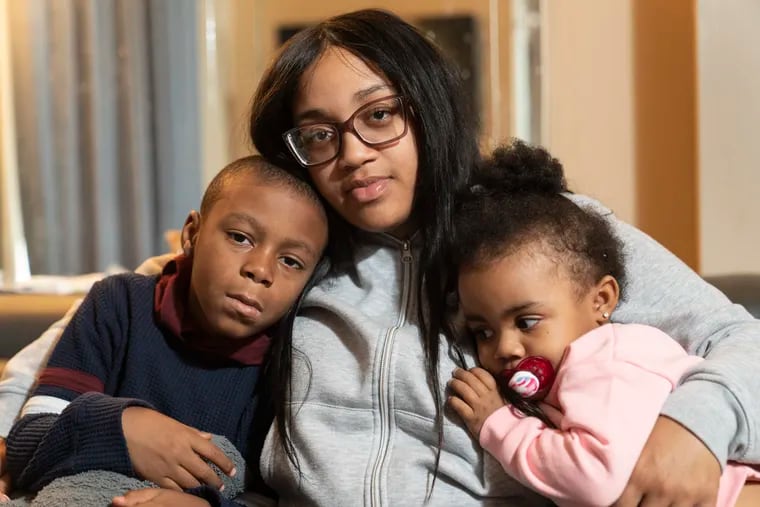 Shaina Moore, center, with her children, Princekai’mir Thompson, left, and his sister Suhara Moore, right, at their home in Philadelphia. Moore and two-year-old Suhara Moore were struck by gunfire in Strawberry Mansion in February.