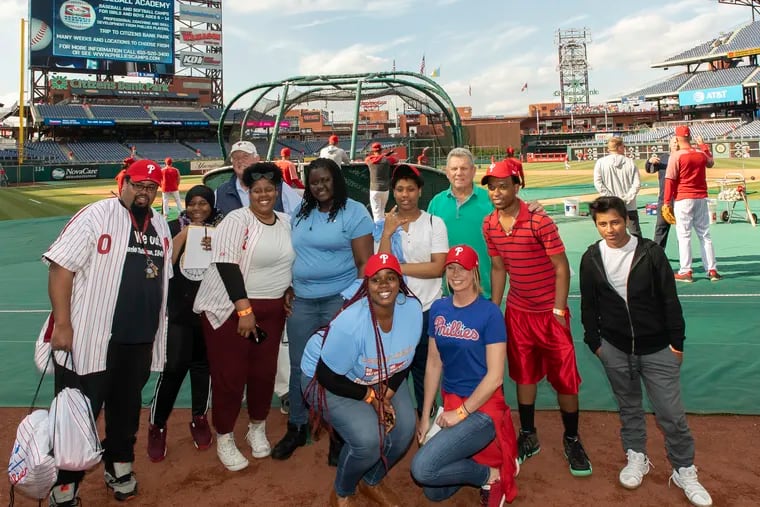 Charlie Manuel (rear left) and Larry Bowa (rear right) pose with some of the Covenant House children and workers before a game against the Tigers.