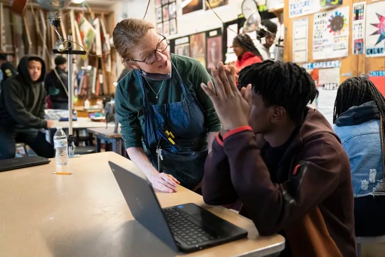 Art teacher Alyce Grunt speaks with a student at Penn Wood High School. As schools across the country struggle to find teachers to hire, more governors are pushing for pay increases and bonuses for the beleaguered profession.