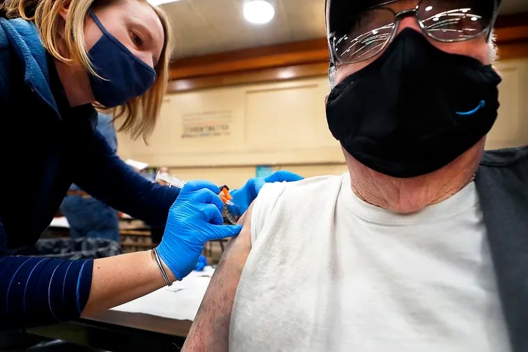 Amber Pedro, a volunteer from Family Practice Laporte, administers the vaccine into the arm of Robert Keen, 84 of Forksville, in the cafeteria of the Sullivan County Elementary School.